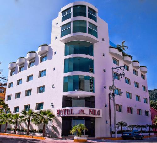 a white building with a hotel miu sign on it at Hotel Nilo in Acapulco