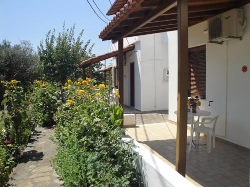a garden outside a house with a table and flowers at Studios Calvinos in Marathokampos