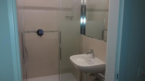 a bathroom with a sink and a glass shower at Hotel Lux in Merano