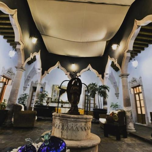 a lobby with a fountain in the middle of a building at Hotel Posada San Miguel in Jerez de García Salinas