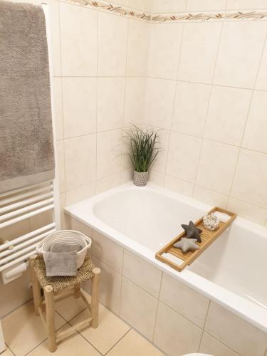 a bathroom with a tub and a chair and a plant at Lexapartments Holiday Appartement mit Sonnenterrasse in Reutlingen