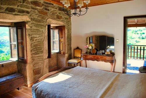 ein Schlafzimmer mit einem Bett, einem Schreibtisch und Fenstern in der Unterkunft Casa de Mendiz in Vale de Mendiz