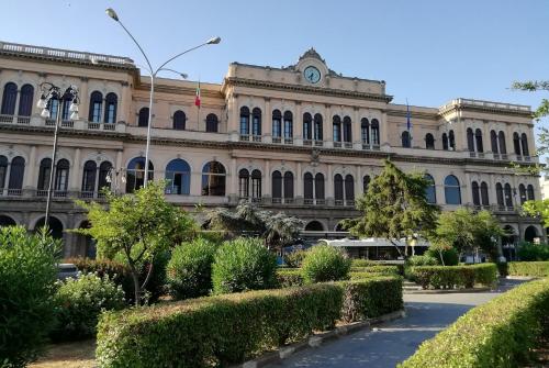 un gran edificio con arbustos delante de él en VENTO di MARE, en Palermo
