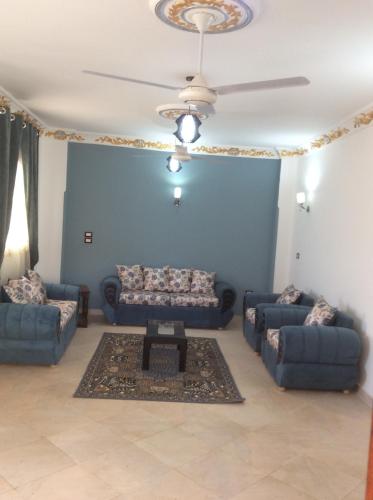 a living room with couches and a ceiling fan at The Brown House in Luxor