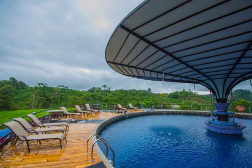 una terraza con sillas y una piscina de agua en Hotel Hacienda Don Paolo, en San Vito