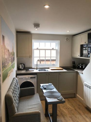 uma cozinha com um sofá, um lavatório e uma mesa em The Lodgings em Beverley