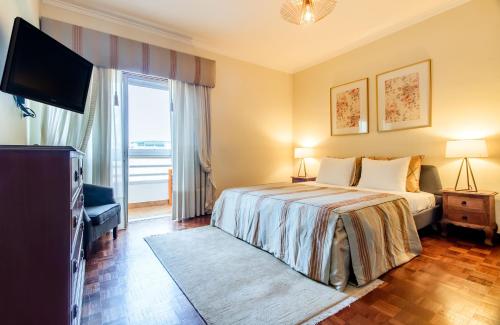 Habitación de hotel con cama y TV en Telheiras Comfortable Stay, en Lisboa
