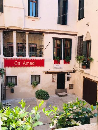 a building with a red sign on the side of it at Ca' Amadi in Venice