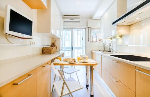 a kitchen with a small table and a tv at Telheiras Comfortable Stay in Lisbon