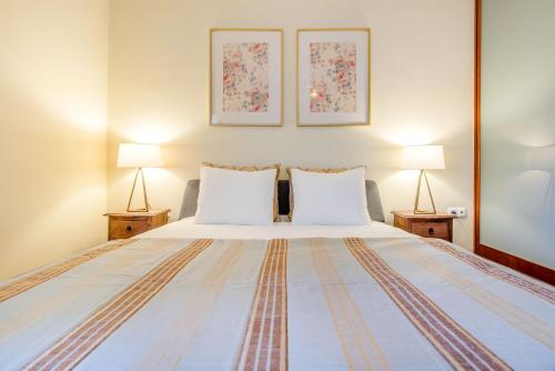 a bedroom with a large bed with two lamps at Telheiras Comfortable Stay in Lisbon