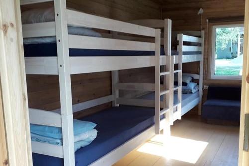 a room with three bunk beds in a cabin at Metsjärve apartments in Põlva