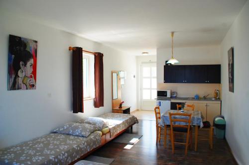 ein Wohnzimmer mit einem Sofa und einem Tisch sowie eine Küche in der Unterkunft Apartments Kolmanic, sea view, free privat parking in Ičići