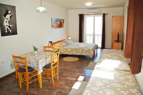 een kamer met 2 bedden en een tafel en stoelen bij Apartments Kolmanic, sea view, free privat parking in Ičići