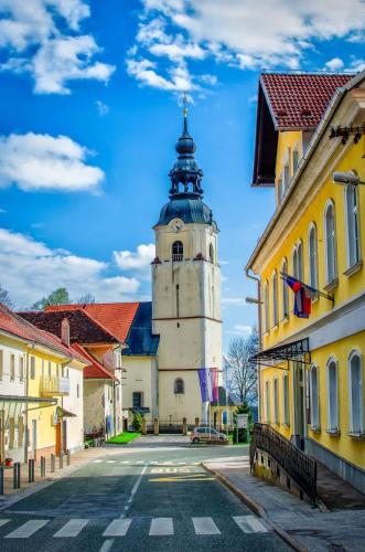 a building with a clock tower in the middle of a street at Guesthouse Urša in Preddvor