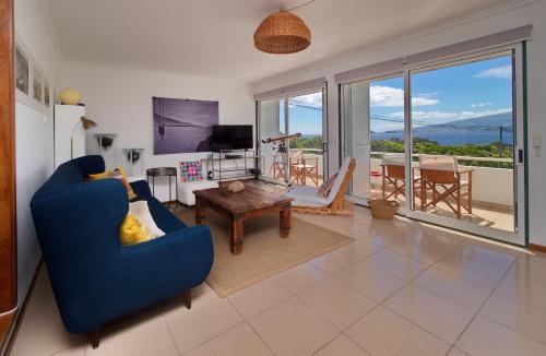 a living room with a blue couch and a table at epicenter PICO in Madalena