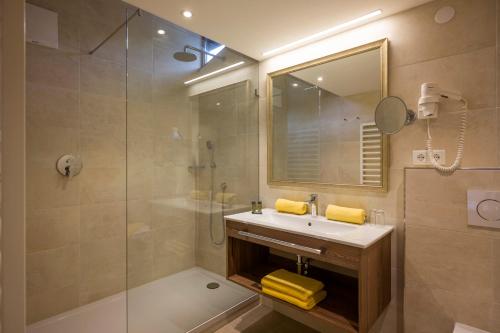 a bathroom with a sink and a shower and a mirror at Hotel-Gasthof zur Schönen Aussicht in Sankt Johann in Tirol