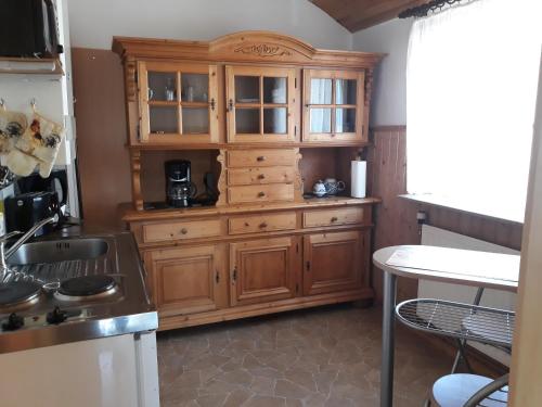 une grande armoire en bois dans une cuisine avec une table dans l'établissement Wanderunterkunft bei Spindler, à Frauenwald