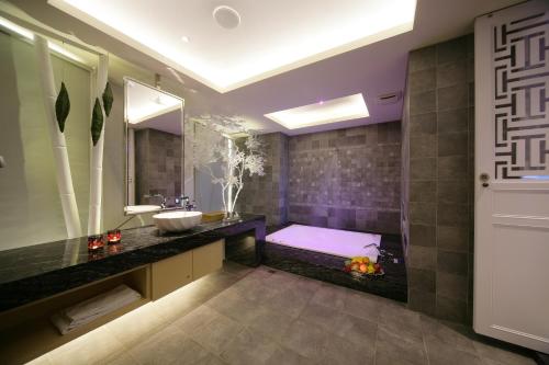 a bathroom with a sink and a bath tub at Dubai Villa Motel in Daya