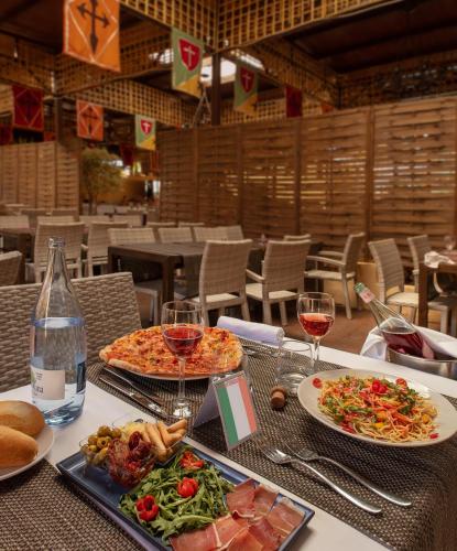 a table with two plates of food and glasses of wine at Magic Robin Hood in Albir
