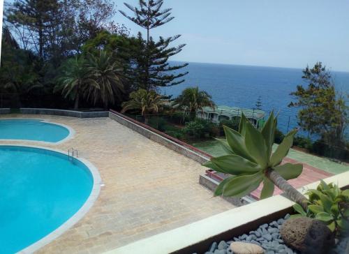 a swimming pool with the ocean in the background at Un Balcon Sur La Mer in Funchal
