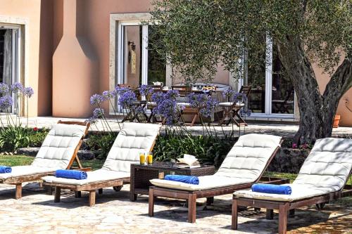 a group of chairs and a table in a courtyard at STONE ROSE VILLA in Agios Ioannis