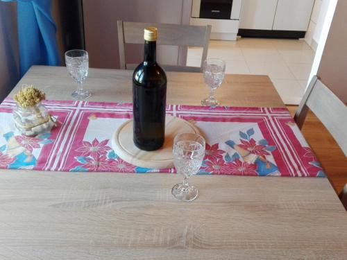 a bottle of wine sitting on a table with glasses at Apartment Josip -Tomic in Miletići