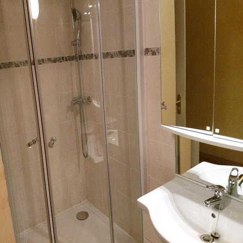 une douche avec une porte vitrée à côté d'un lavabo dans l'établissement Villa Sénégas, à La Roque-sur-Cèze