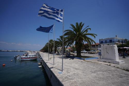 two flags on a dock next to a body of water at Evel House in Skala Kallirakhis