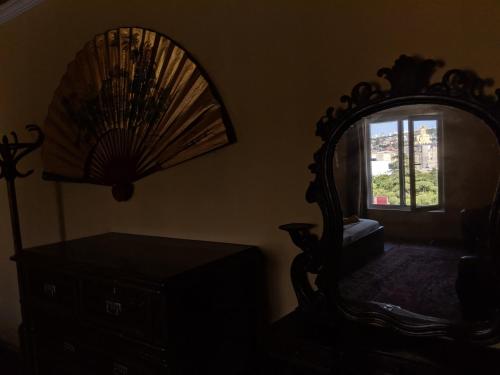 a room with a mirror and a chair and a window at Diwan in Tbilisi City