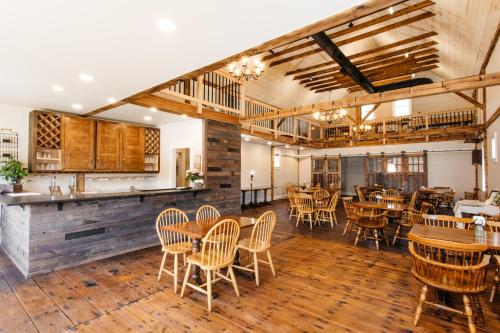 ein Restaurant mit Holzböden, Tischen und Stühlen in der Unterkunft Reynolds House Inn in Barre