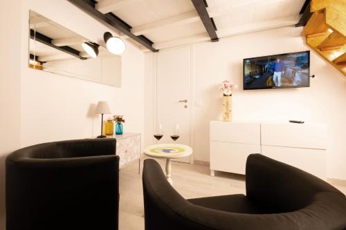 un soggiorno con 2 sedie e una TV a parete di Il nido - Cozy studio apartment in Santa Croce a Firenze