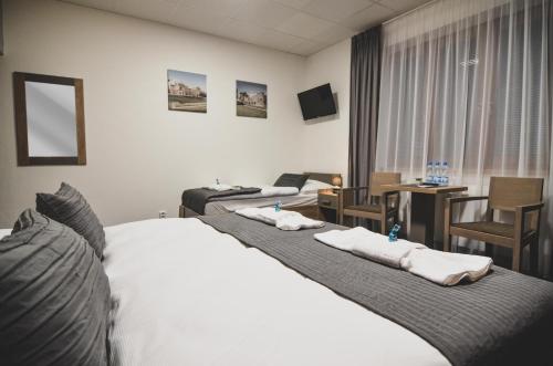 a hotel room with two beds and a table at Penzion Pod Radnicí in Hustopeče