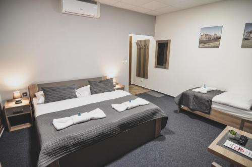 a bedroom with a bed with two towels on it at Penzion Pod Radnicí in Hustopeče