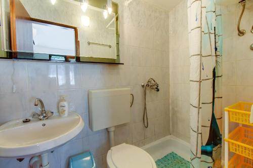 a bathroom with a sink and a toilet and a mirror at House Verica in Veli Lošinj