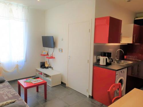 Elle comprend une petite cuisine équipée d'un réfrigérateur rouge et d'une table. dans l'établissement LE 43 NICE PORT, à Nice