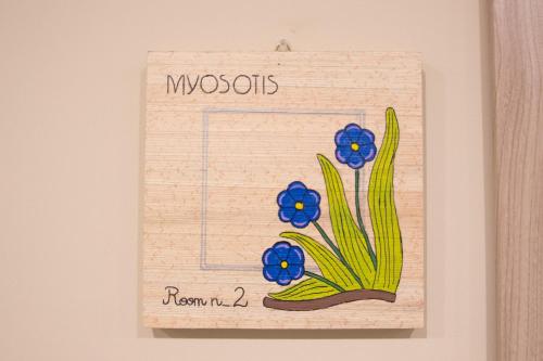 a card with a picture of blue flowers on a wall at Papiroom's in Siracusa