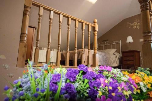 a bed with a bunch of flowers in a room at Casa rural Los Bodones in Quintanilla Riopico