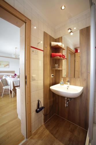 a bathroom with a white sink and a table at Schätzlhof OHG in Ruderting