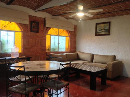 a living room with a couch and a table and chairs at Mama Chuy Hotel & Villas Ajijic in San Juan Cosalá