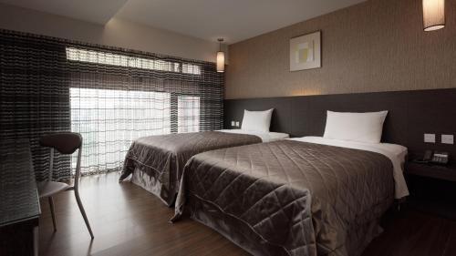 a hotel room with two beds and a window at Fine Hotel in Kaohsiung