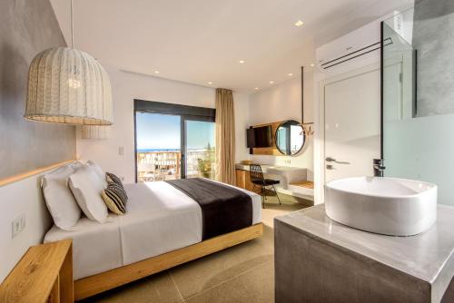 a bedroom with a bed with a tub and a sink at Calma Villas Crete - heated pool in Sissi