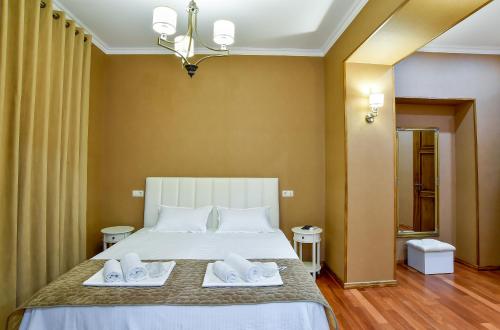 a bedroom with a bed with two towels on it at Exclusive Apartament the Heart of Old Kutaisi in Kutaisi