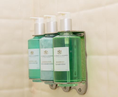 a group of three bottles of soap on a shelf at Charlroy Motel in Seaside Park