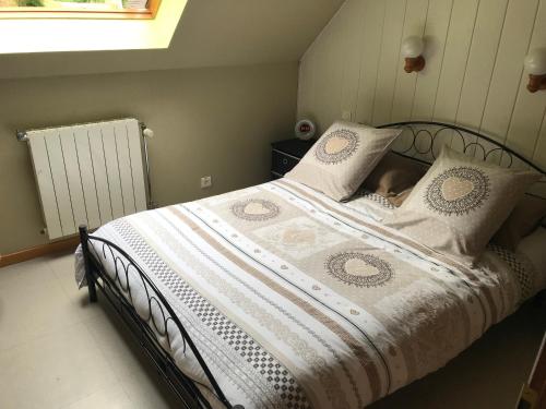 1 cama con edredón y almohadas blancos en Gîte du ROCHER, en Lapoutroie