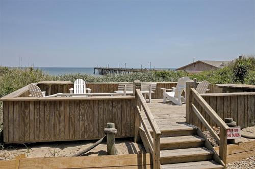 a wooden deck with chairs on the beach at Colonial Inn in Nags Head