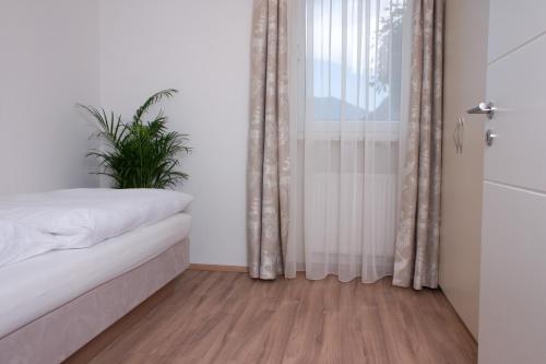 a bedroom with a bed and a window with a plant at Hölbinger Alm - Apartments in Anger