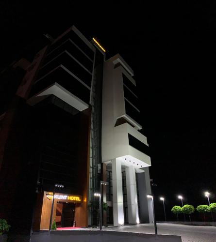 a tall building at night with lights in front of it at Kuint Hotel in Peje