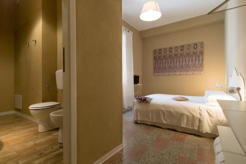 1 dormitorio con 1 cama y baño con aseo en BluLassù City Center Rooms en Cagliari