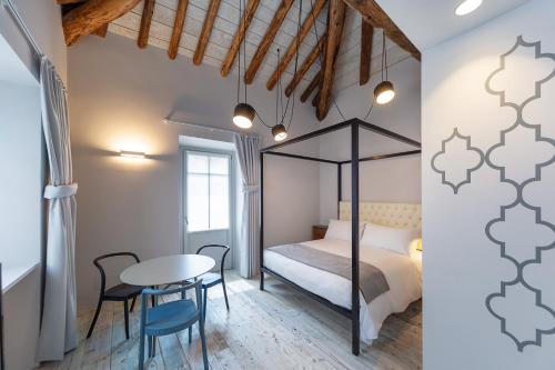 a bedroom with a bed and a table and chairs at Maison Alliod in Saint Vincent
