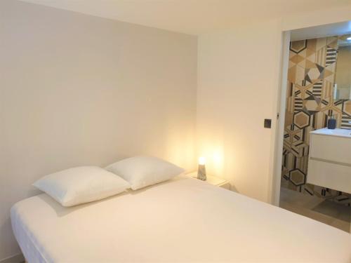 - un lit blanc avec deux oreillers dans une chambre dans l'établissement DUPLEX BALCON CENTRE MER 203, à Nice